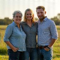 The Thompson family, proud dairy farmers partnering with Warrnambool Dairy Foods, smiling in their field.